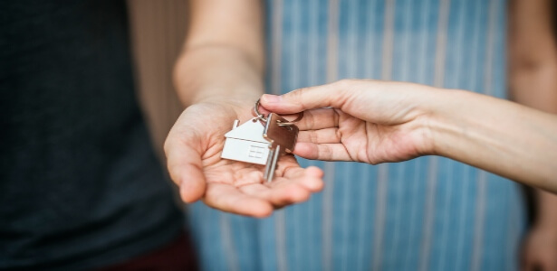 Person receiving the keys to their house after successful mortgage application