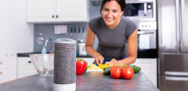Woman using smart home assistant to help her cook