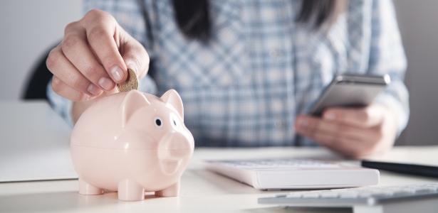 Woman saving money in piggy bank 